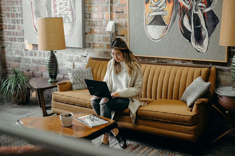 Une apprenante suit sa formation en ligne depuis son salon